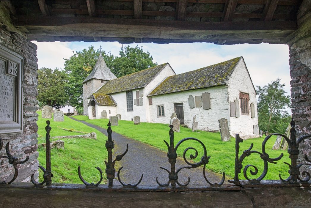 The well-preserved Norman and medieval church in Llanfilo viewed through the lychgate