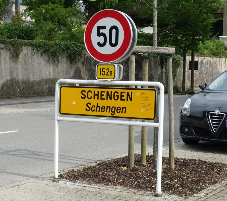 City limit sign for Schengen (with graffito requesting visas)