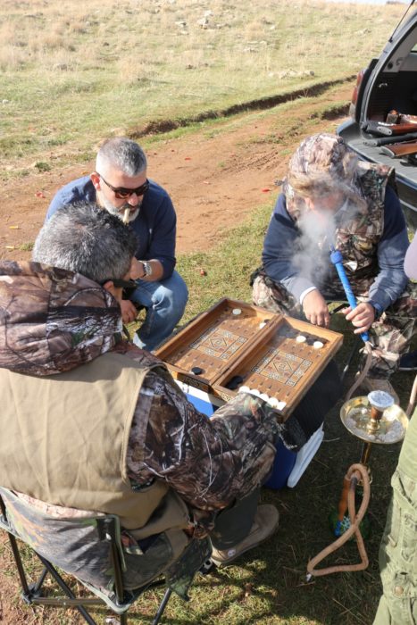 Hunters indulging in backgammon and shisha