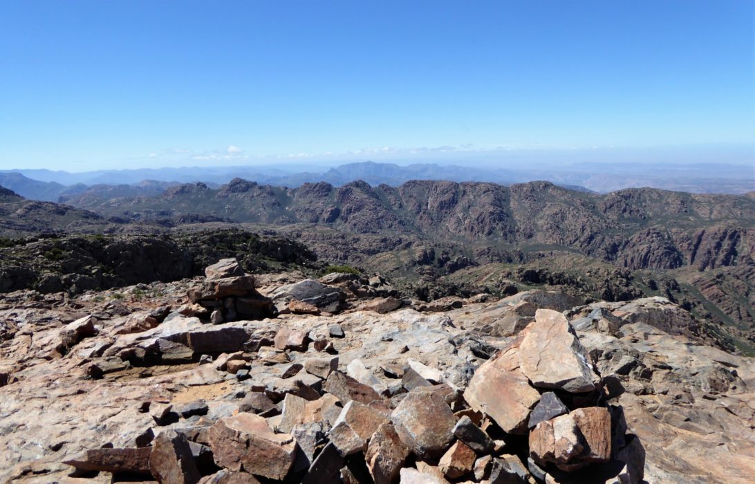 An early start leads by way of a steady ascent to the summit of Jebel Tikwyene. To the right summits of the parallel ridge of Targa N’Touchka form the western guardians. From here most of the north western summits can be seen.