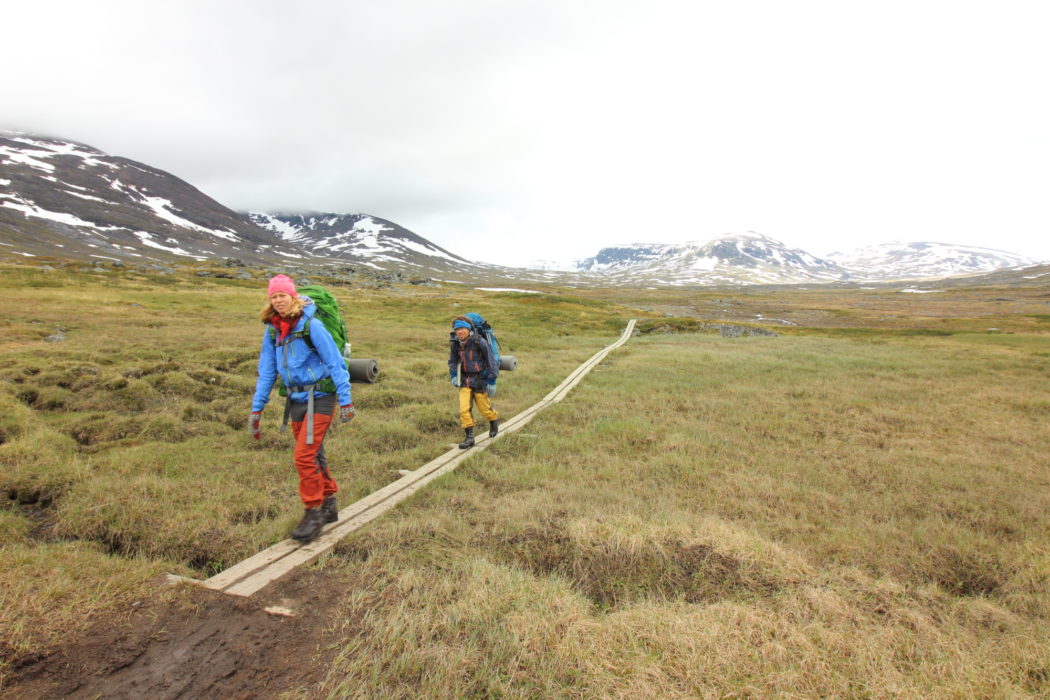 4 Walkers heading for Alesjaure, boardwalks are common in boggy areas.