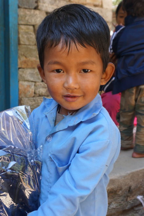 A child at Kinja holding his new uniform