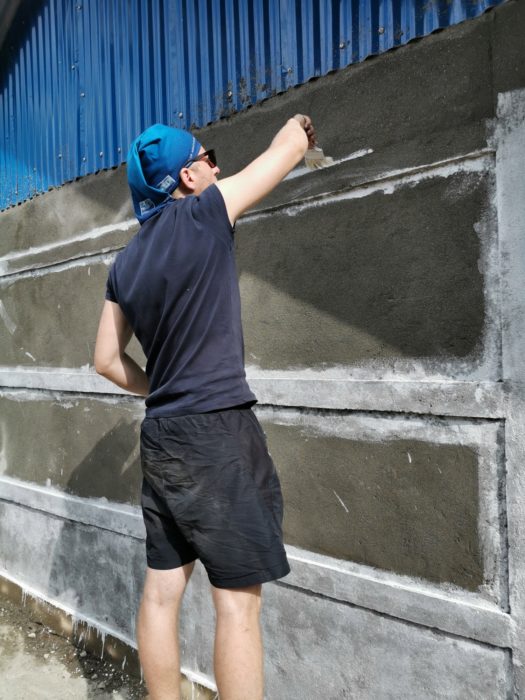 Ioan painting the side of the school