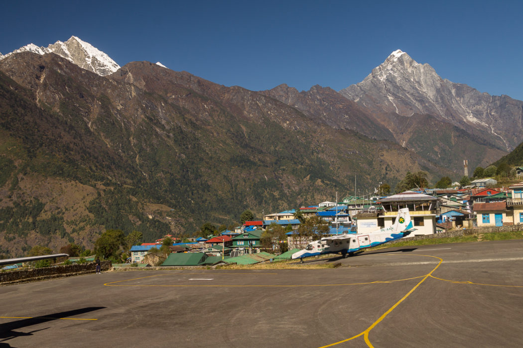 A Tara Air Dornier Do 228 212 Aircraft Speeds Down The Runway At Lukla Airport In The Background Are Karyolung Left 6511M And Nupla 5885M