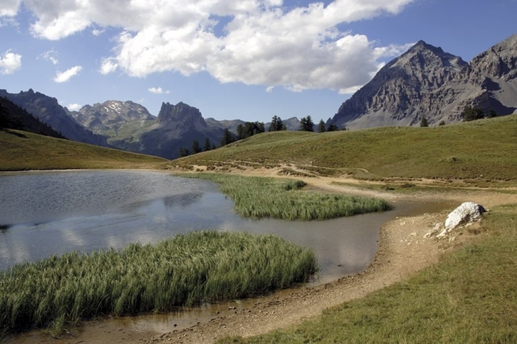 A pleasant little lake sits on the grassy Col des Thures high above the Vallée Étroite. Seen on a variant route of the GR5 trek through France.